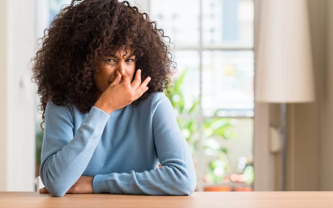 Woman closing nose because of smelly AC