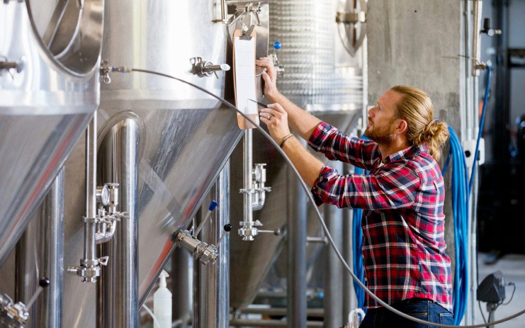 Brewery worker inspecting tanks