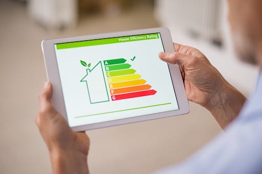 Homeowner looking at house efficiency rating on tablet to try and lower utility bills