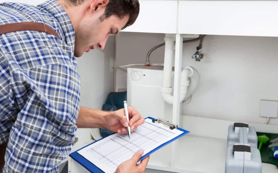 Professional plumber using checklist to perform inspection