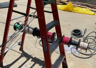 a ladder holding different types of wires for a home rewiring